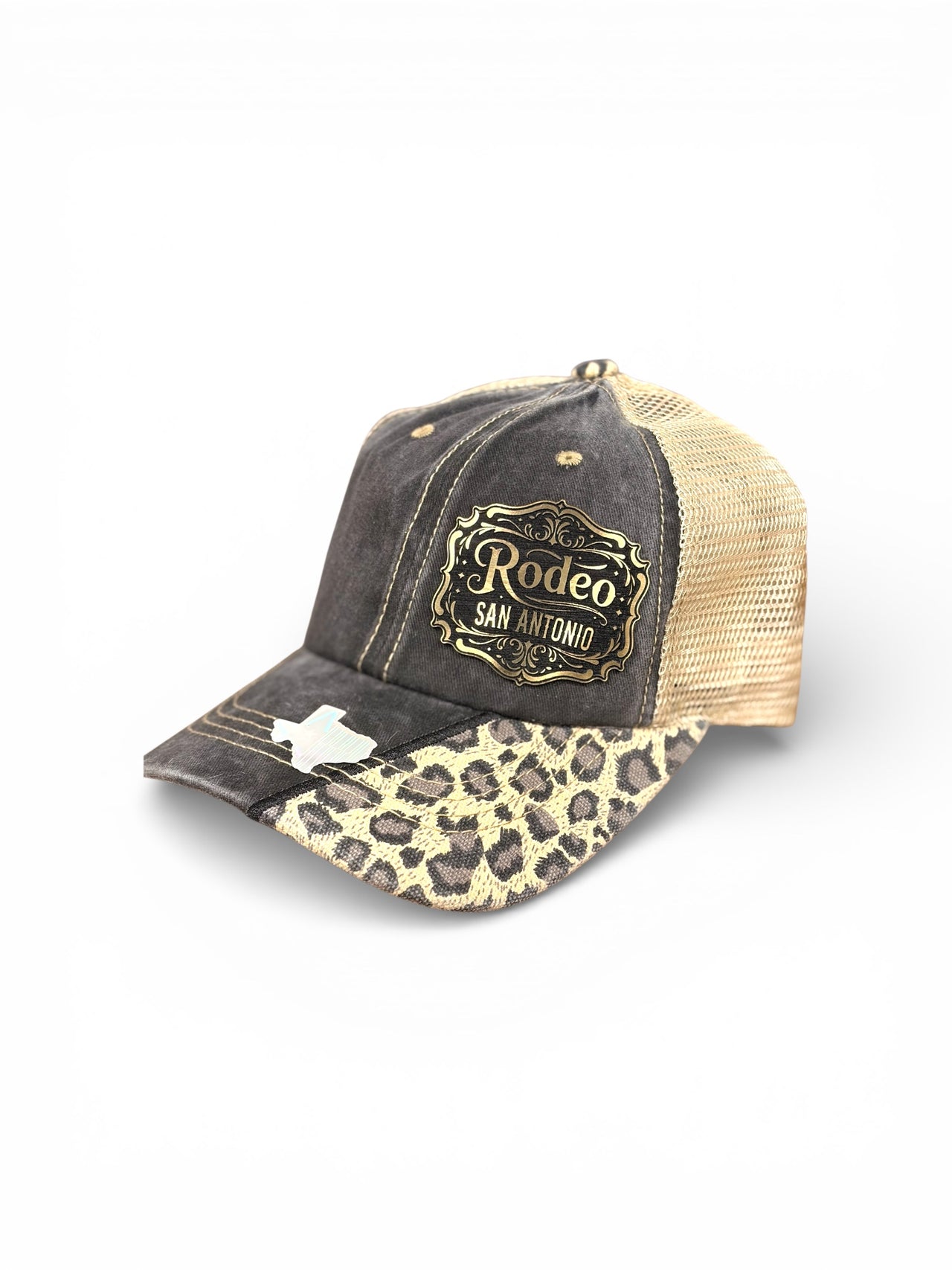 Distressed charcoal and leopard print Rodeo San Antonio trucker hat with gold Western patch, cream mesh back, and Texas-shaped holographic accent on the bill